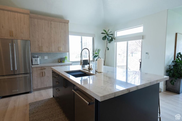 14661 S Rock Canyon Cir W, Herriman, UT 84096 - kitchen with appliances with stainless steel finishes, a sink, light wood-style flooring, light stone counters, and a center island with sink