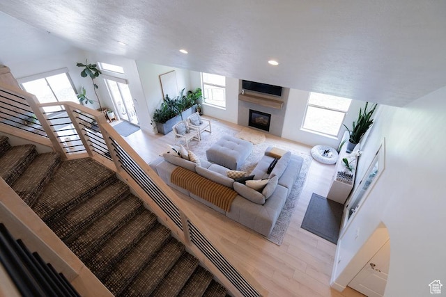 14661 S Rock Canyon Cir W, Herriman, UT 84096 - living area featuring a glass covered fireplace, light wood-style flooring, recessed lighting, and stairway