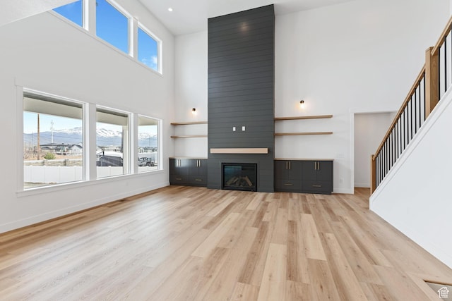 3010 W Willow Dr S, Lehi, UT 84043 - unfurnished living room featuring baseboards, a high ceiling, a healthy amount of sunlight, and light wood-style floors