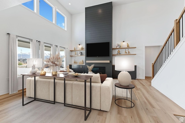 3010 W Willow Dr S, Lehi, UT 84043 - living area with baseboards, a large fireplace, light wood-style flooring, and a towering ceiling