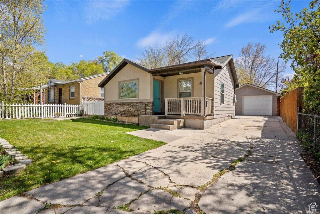 751 E 32nd St, Ogden, UT 84403 - view of front of property with stone siding, covered porch, fence, an outbuilding, and a front yard