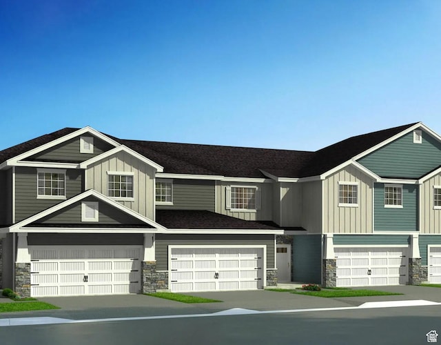 view of front facade featuring board and batten siding, an attached garage, and stone siding