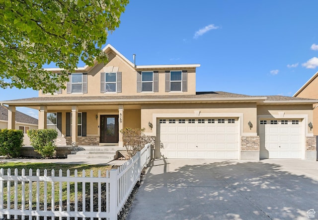traditional home with concrete driveway, fence, and stucco siding