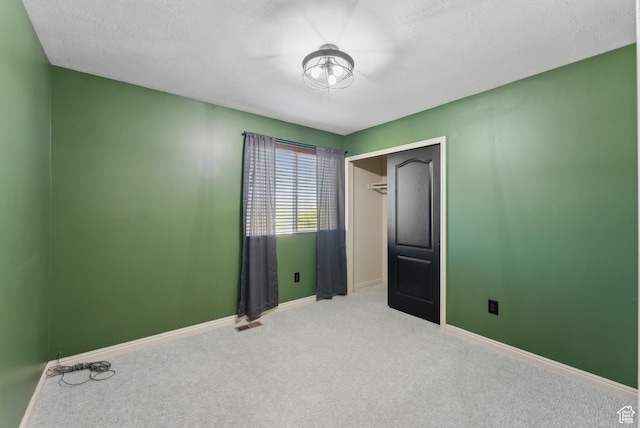 unfurnished bedroom featuring carpet floors, a closet, visible vents, and baseboards