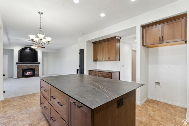 kitchen featuring recessed lighting, dark countertops, decorative light fixtures, and a tile fireplace