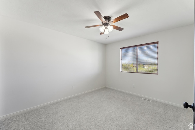 empty room featuring ceiling fan, baseboards, visible vents, and carpet