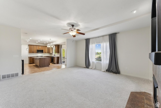 unfurnished living room featuring recessed lighting, plenty of natural light, visible vents, and ceiling fan with notable chandelier
