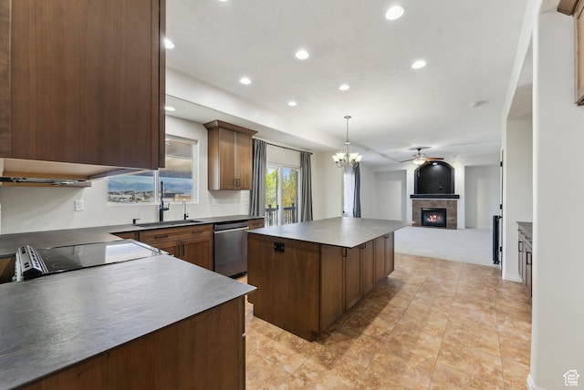 kitchen featuring a center island, stainless steel dishwasher, a sink, open floor plan, and a tiled fireplace