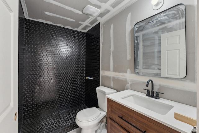 bathroom featuring toilet, vanity, and a stall shower