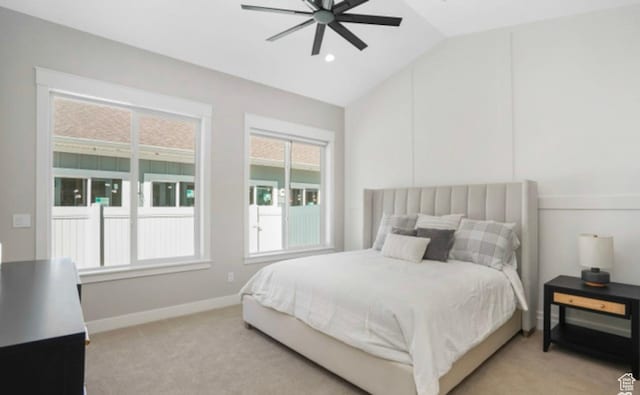 bedroom with baseboards, lofted ceiling, ceiling fan, and light carpet