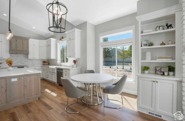 kitchen featuring light countertops, wood finished floors, visible vents, tasteful backsplash, and hanging light fixtures