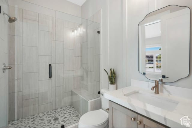 full bath with vanity, a shower stall, and toilet