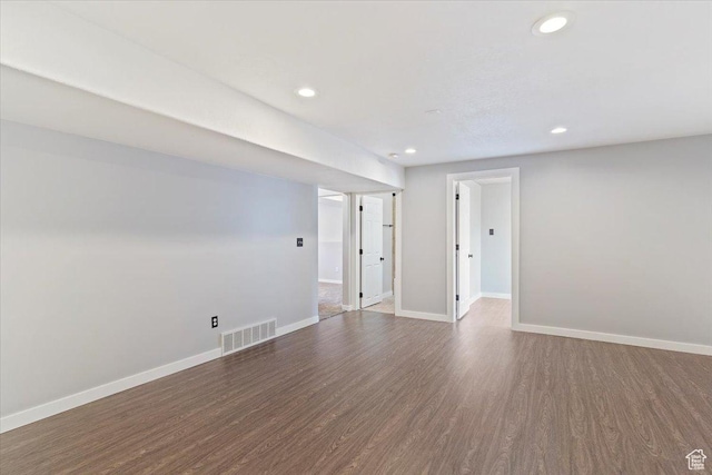 empty room with baseboards, wood finished floors, visible vents, and recessed lighting