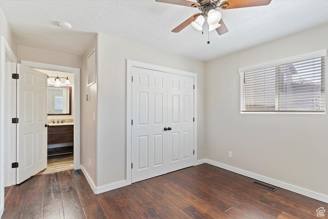unfurnished bedroom featuring a closet, ceiling fan, baseboards, dark wood-style flooring, and visible vents
