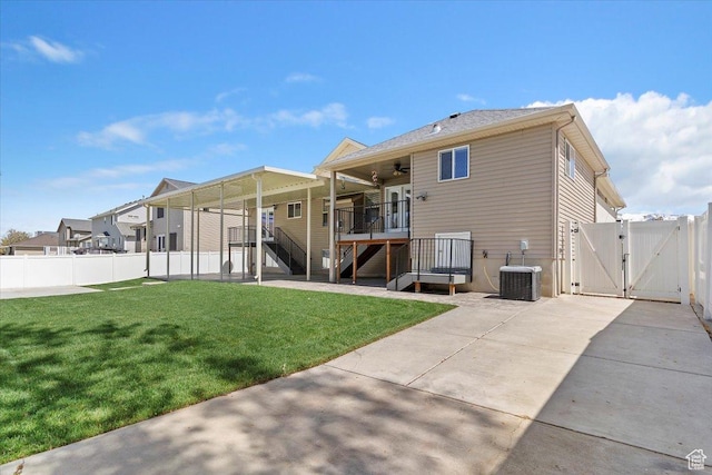 rear view of property featuring stairway, a fenced backyard, a ceiling fan, and a gate