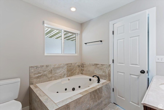bathroom with toilet, a tub with jets, and vanity
