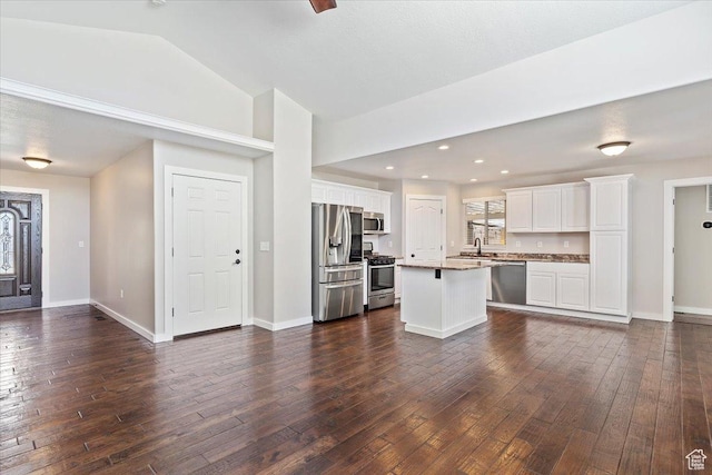 interior space featuring lofted ceiling, a sink, and dark wood-style flooring