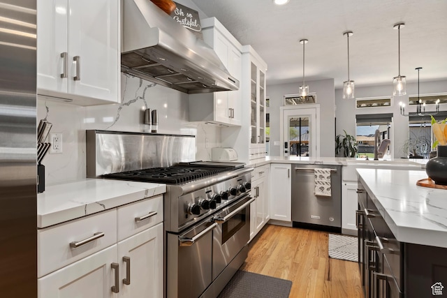 468 E 12000 S, Draper, UT 84020 - kitchen with wall chimney exhaust hood, backsplash, white cabinetry, light stone counters, and appliances with stainless steel finishes