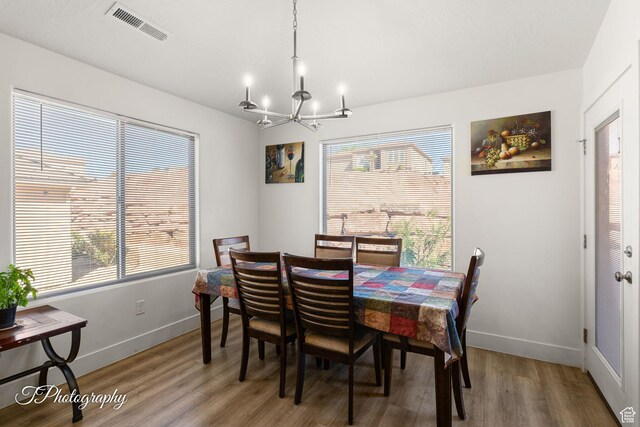 2261 S Tonaquint Dr W Unit 55, St George, UT 84770 - dining room featuring baseboards, a notable chandelier, wood finished floors, and visible vents