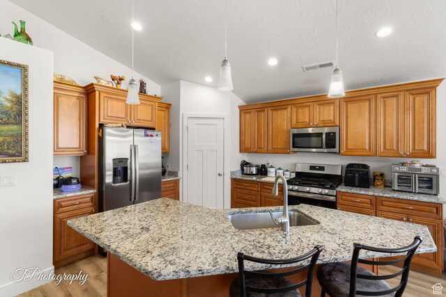 2261 S Tonaquint Dr W Unit 55, St George, UT 84770 - kitchen featuring visible vents, a sink, brown cabinets, and appliances with stainless steel finishes