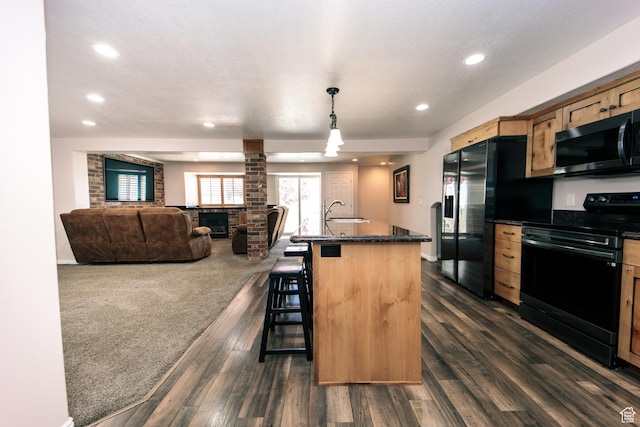 3611 W 850 S, Syracuse, UT 84075 - kitchen with a kitchen breakfast bar, a sink, dark countertops, decorative columns, and black appliances