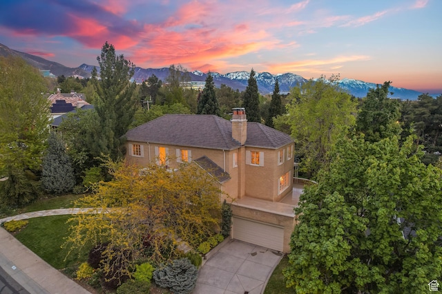 1500 E Arlington Dr, Salt Lake City, UT 84103 - view of front of home with a chimney, driveway, a mountain view, a garage, and stucco siding