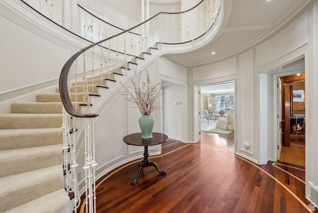 1500 E Arlington Dr, Salt Lake City, UT 84103 - foyer with stairway, a high ceiling, wood finished floors, a decorative wall, and crown molding