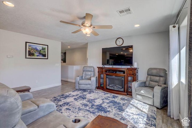 715 S Peachtree Dr, Toquerville, UT 84774 - living area featuring baseboards, a glass covered fireplace, visible vents, wood finished floors, and ceiling fan