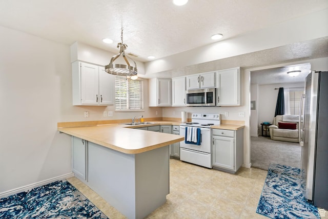 6160 S 1350 E, South Ogden, UT 84405 - kitchen with a textured ceiling, stainless steel microwave, white range with electric stovetop, freestanding refrigerator, and a peninsula