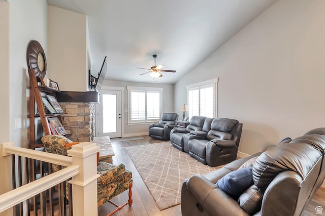 living area with light wood-style floors, lofted ceiling, a ceiling fan, and baseboards