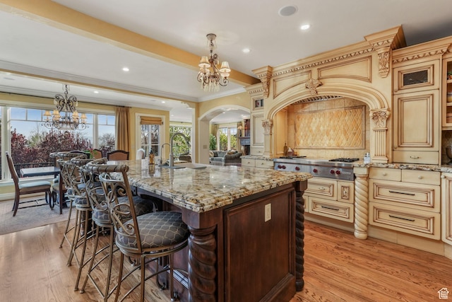 1230 E 11th Ave N, Salt Lake City, UT 84103 - kitchen featuring arched walkways, a sink, an inviting chandelier, and a breakfast bar area