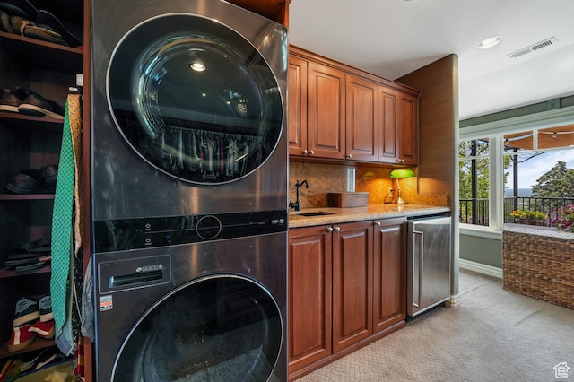 1230 E 11th Ave N, Salt Lake City, UT 84103 - washroom with stacked washing machine and dryer, light colored carpet, cabinet space, and bar with sink