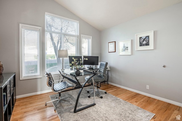 home office featuring vaulted ceiling, baseboards, and light wood-style flooring