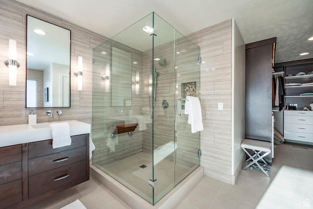 bathroom with recessed lighting, a shower stall, tile patterned floors, and vanity