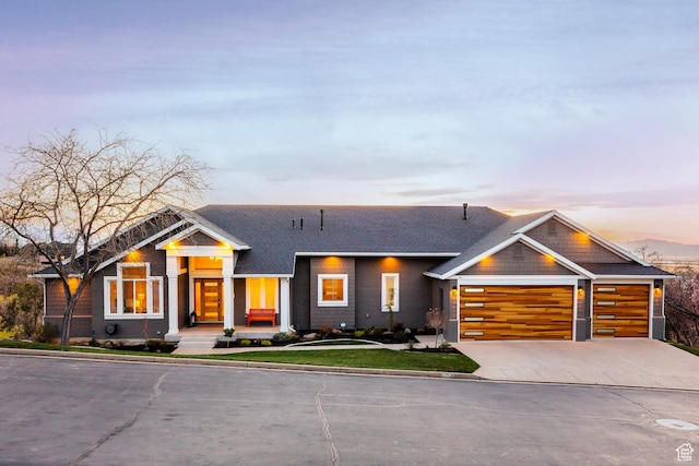 view of front facade featuring concrete driveway, a lawn, and a garage