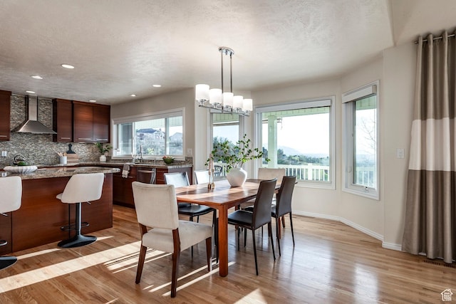 dining space with recessed lighting, baseboards, a wealth of natural light, and light wood-type flooring
