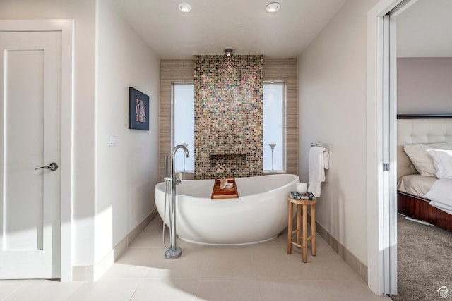 bathroom featuring tile patterned floors, baseboards, recessed lighting, a freestanding tub, and connected bathroom