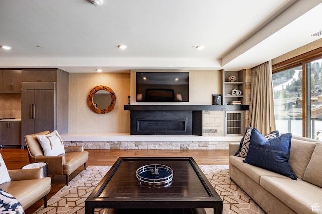 living room with recessed lighting, wood finished floors, visible vents, and a fireplace