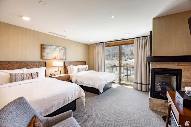 carpeted bedroom with access to outside and a fireplace