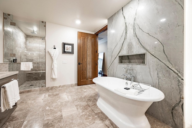 full bathroom with tile walls, a freestanding tub, vanity, and tiled shower