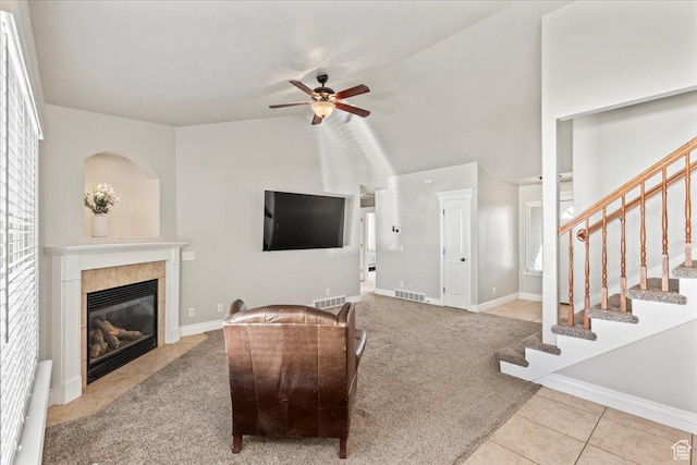 7134 S Rialto Way, West Jordan, UT 84081 - living area with a tiled fireplace, ceiling fan, tile patterned floors, stairs, and vaulted ceiling