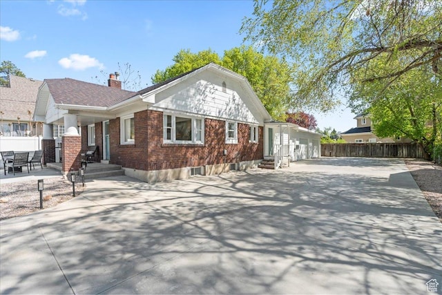 exterior space with brick siding, fence, a chimney, and entry steps