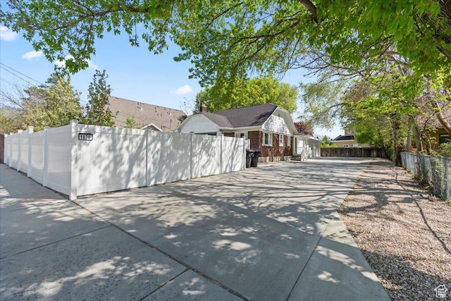 exterior space featuring concrete driveway and fence