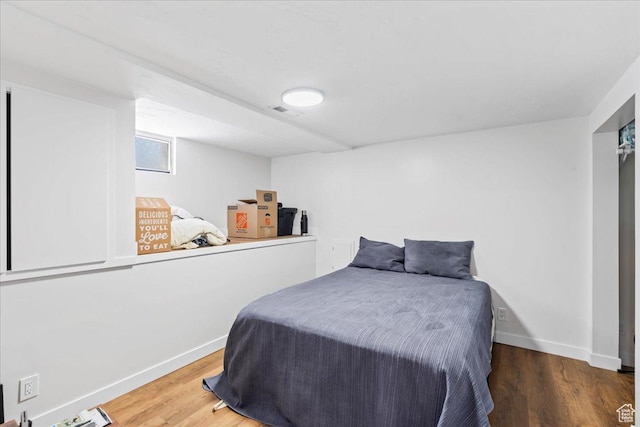 bedroom featuring baseboards and wood finished floors