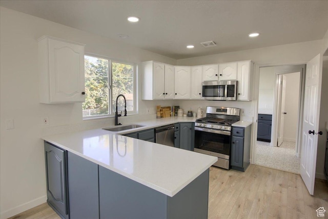 1166 E 4875 S, Ogden, UT 84403 - kitchen featuring stainless steel appliances, visible vents, a sink, a peninsula, and white cabinetry