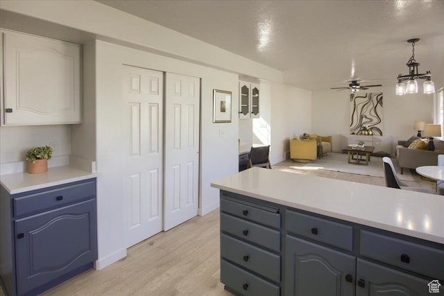 1166 E 4875 S, Ogden, UT 84403 - kitchen with blue cabinets, light wood-type flooring, open floor plan, a ceiling fan, and light countertops