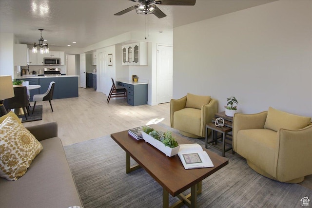 1166 E 4875 S, Ogden, UT 84403 - living area with light wood finished floors and ceiling fan with notable chandelier