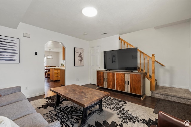 325 E 2300 N, North Ogden, UT 84414 - living area featuring dark wood-type flooring, baseboards, arched walkways, and stairs