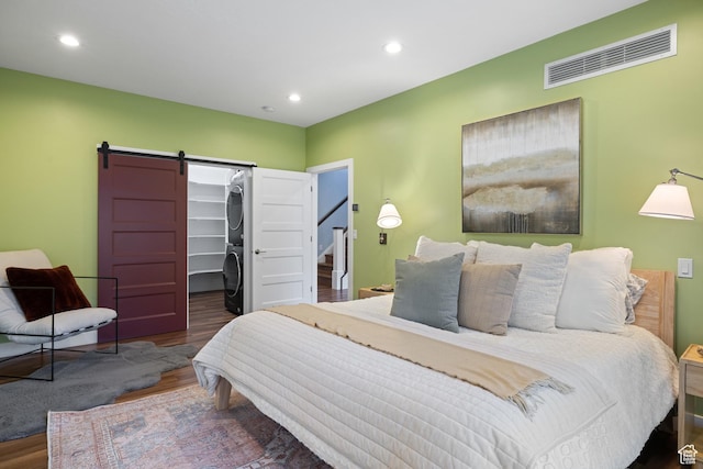 1263 E Chapman Ct, Alpine, UT 84004 - bedroom featuring stacked washer / drying machine, a barn door, wood finished floors, a spacious closet, and recessed lighting