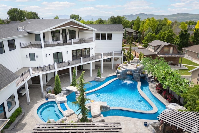 1263 E Chapman Ct, Alpine, UT 84004 - rear view of house with a pool with connected hot tub, a balcony, a mountain view, roof with shingles, and a residential view